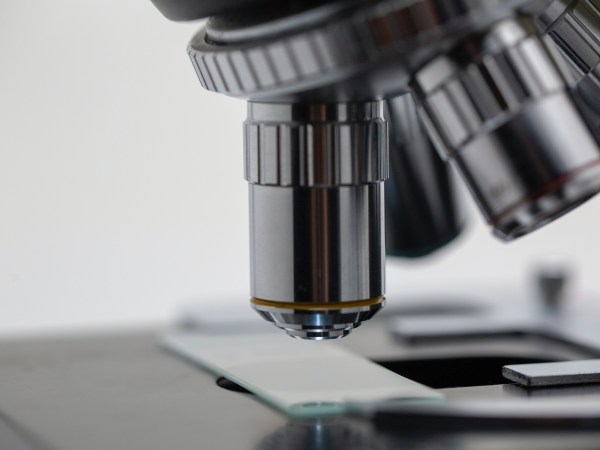 A close-up view of a microscope and a specimen slide.