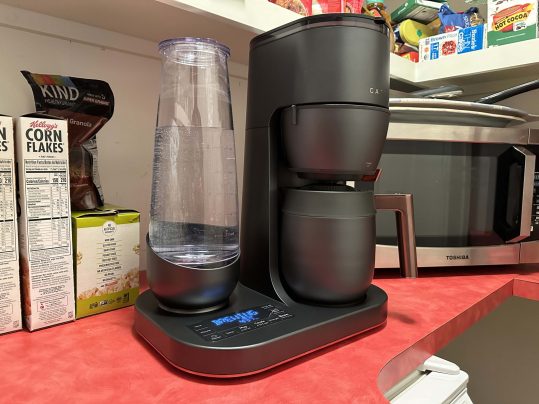 Café Specialty Grind and Brew Coffee Maker on a red countertop in front of a microwave