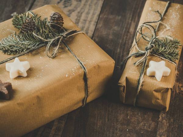 holiday gifts wrapped in brown paper with pine needles