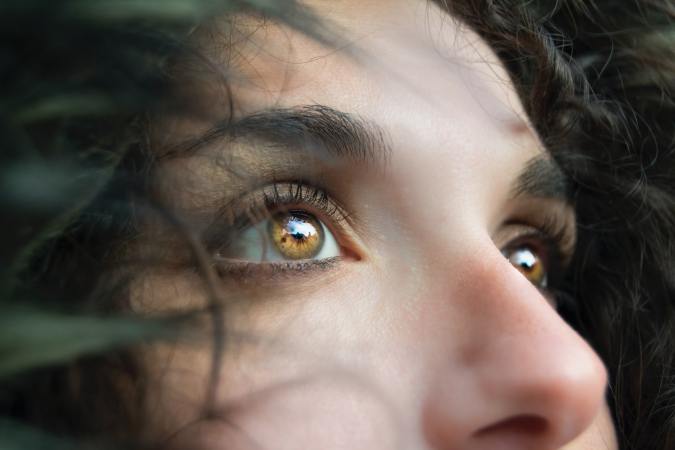 a close-up of a woman with brown eyes showing her nose