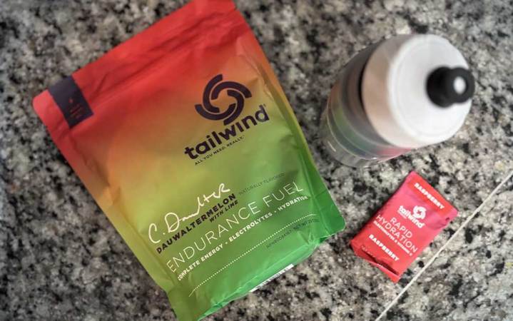 A package of watermelon-flavored Tailwind Nutrition electrolyte mix on a kitchen counter near a water bottle.