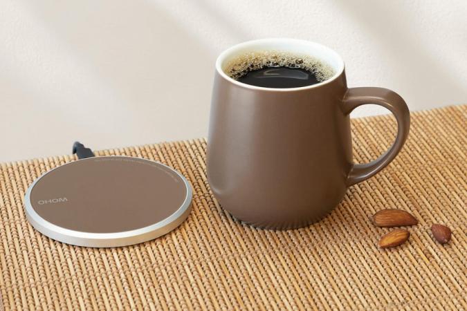 This self-heating mug system double as a wireless phone charger