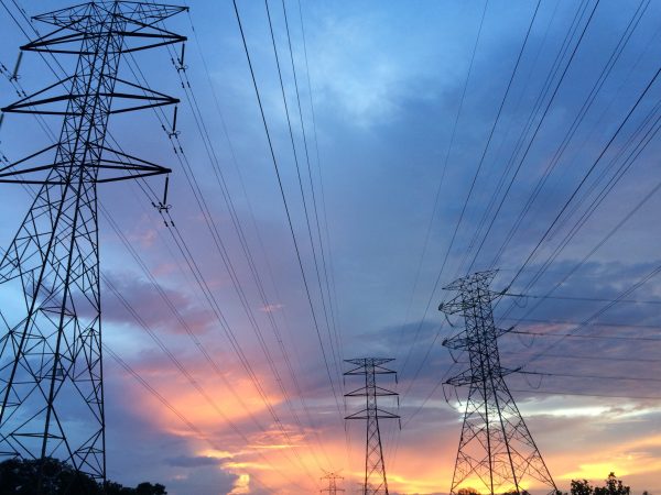 Power lines across sunset and cloud-filled sky.