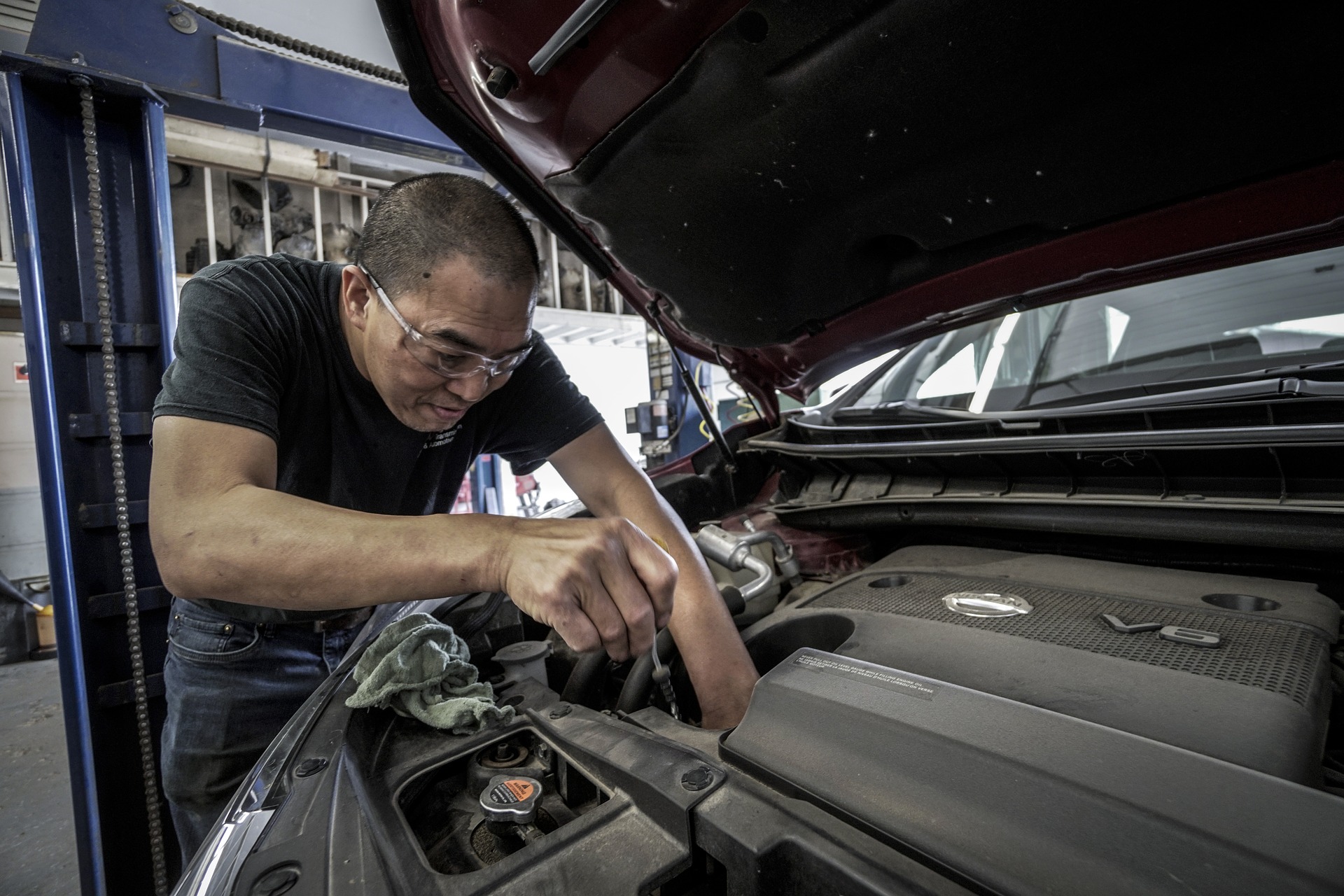 Repairman doing an oil change on car.