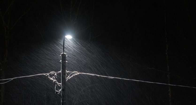 Electric lamppost in winter storm.