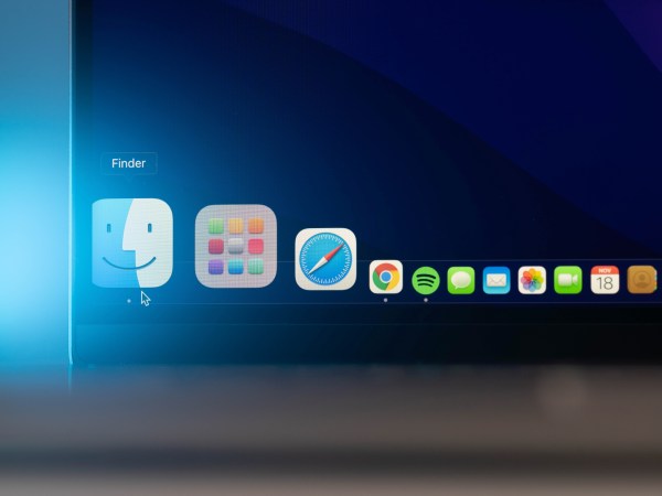 A Mac computer with the Dock visible, showing a mouse pointer over the Finder icon and other Apple icons next to it.