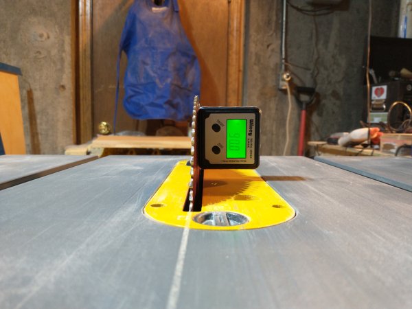 A table saw blade tuned up and straightened to exactly vertical at 90 degrees.