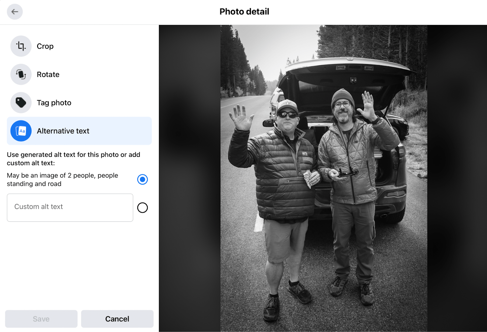 A screenshot of alt text being generated for a black and white photo of two people waving next to a car by the side of the road.