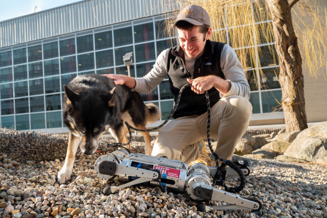 A four-legged robot with a black dog and computer programmer