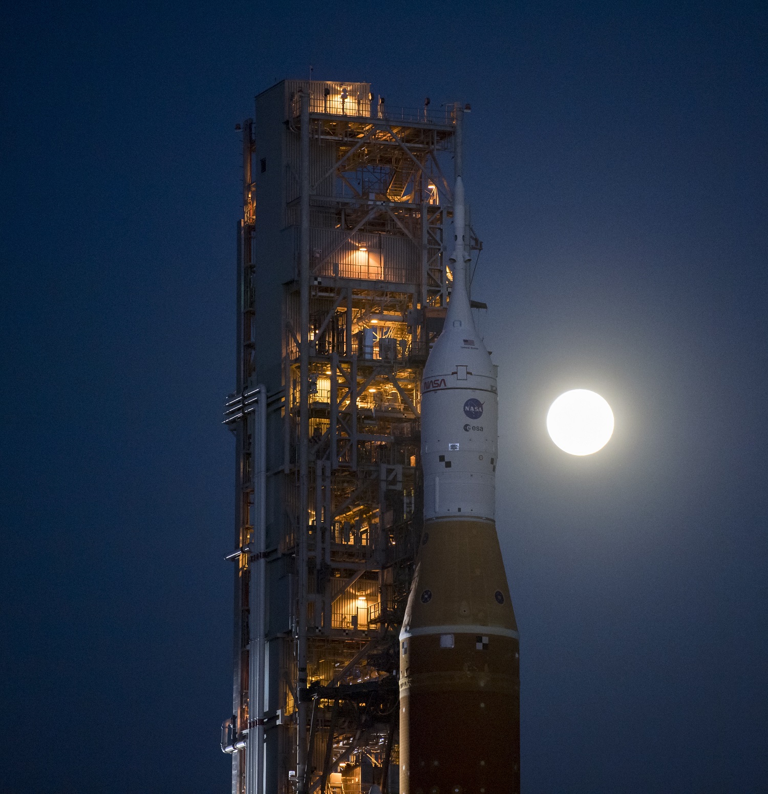 Full moon behind the NASA SLS rocket on the launchpad at Kennedy Space Center in Florida