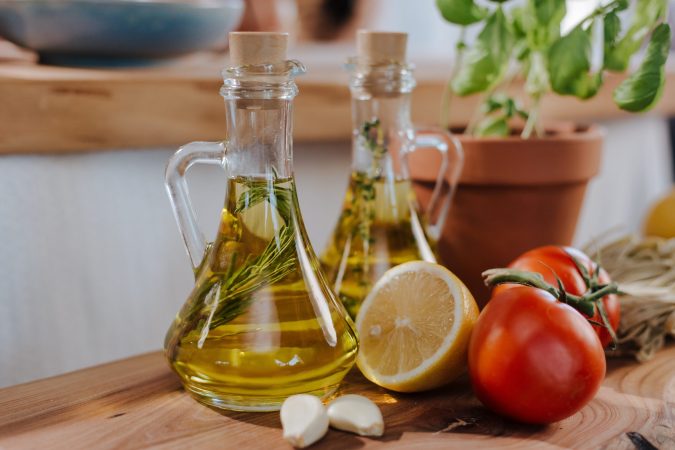 Oil containers with fruits and vegetables in kitchen.