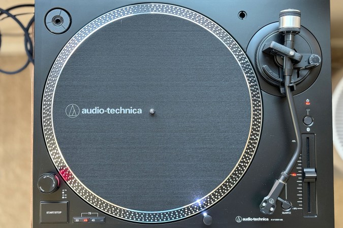  A black Audio-Technica 120XBT-USB Bluetooth turntable shown from above without its dust cover, but with it's light turned on