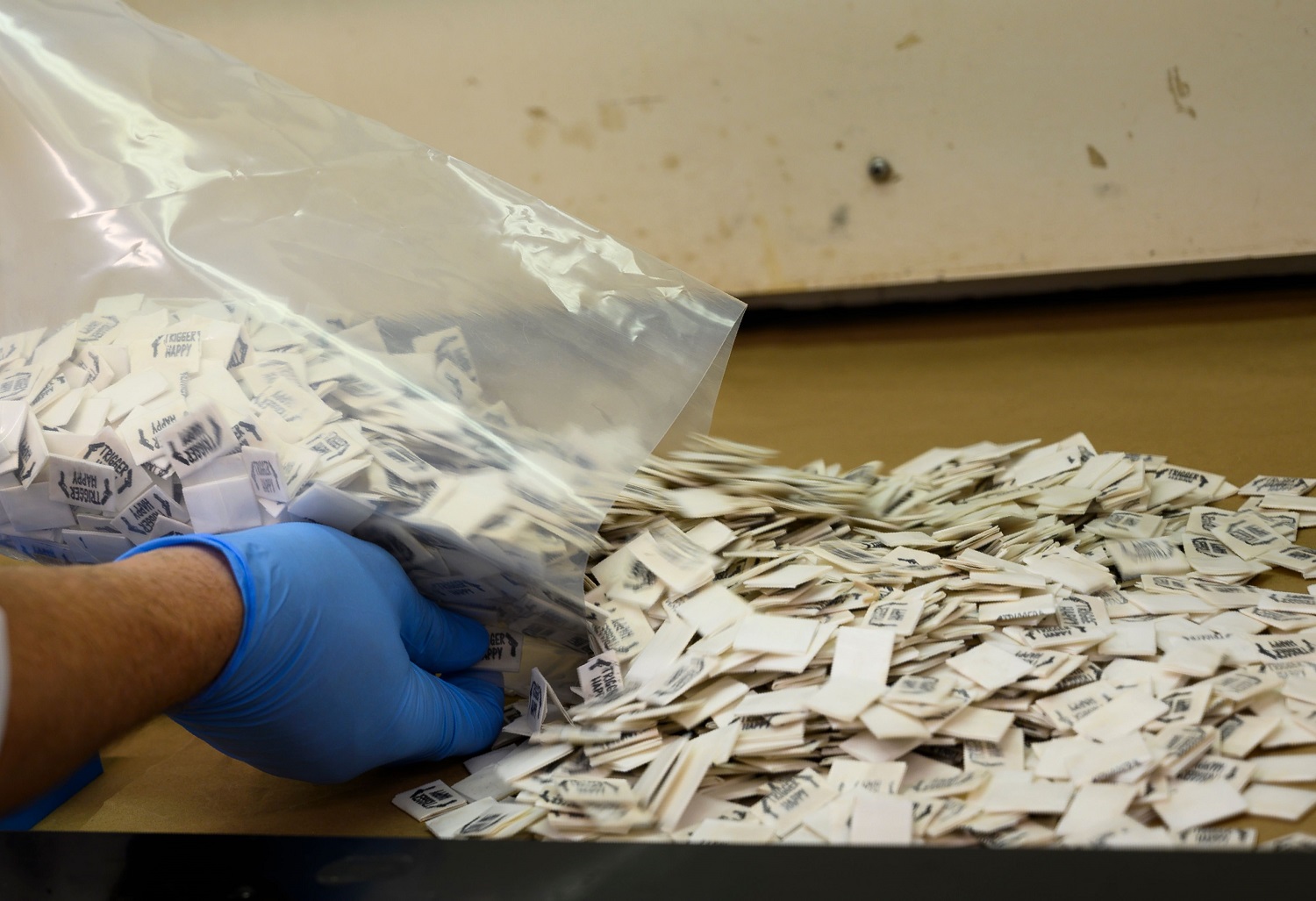 Fentanyl packs collected by the DEA being handled by a blue glove during the opioid crisis