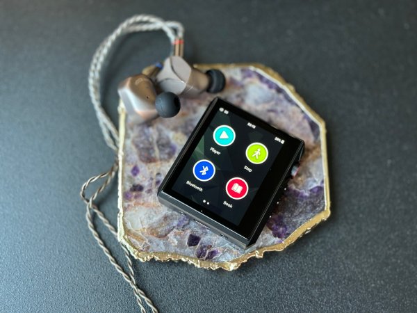  Small black square Hidizs AP80 Pro-X DAP sitting on a marble coaster with titanium IEMs