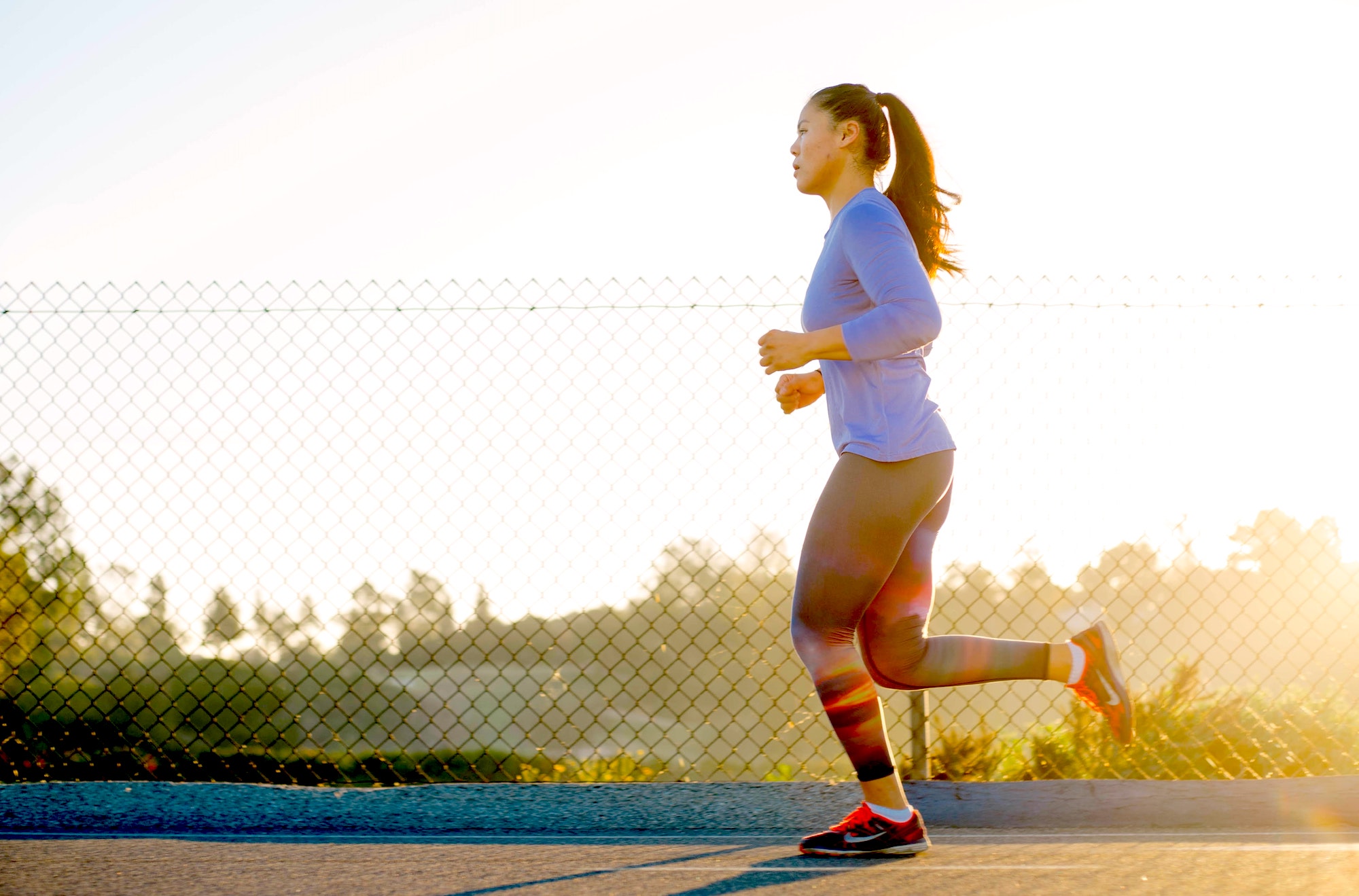 an asian woman on a run outside