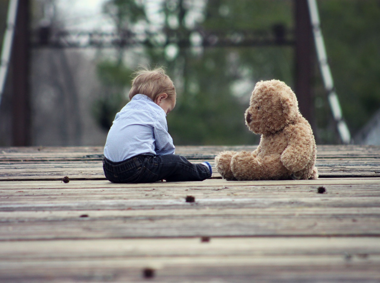 A child playing with a bear.