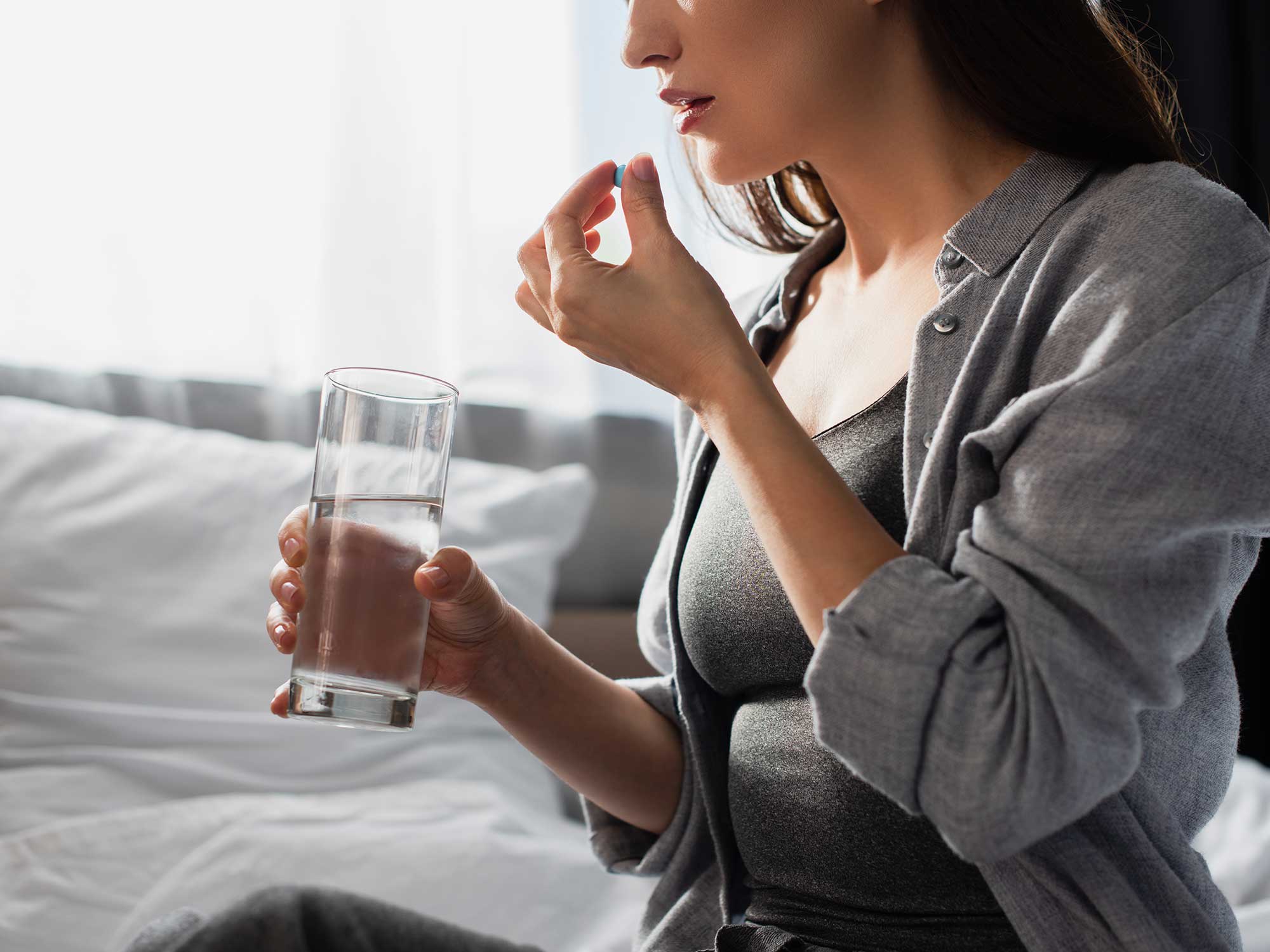 A photo of a person taking a pill