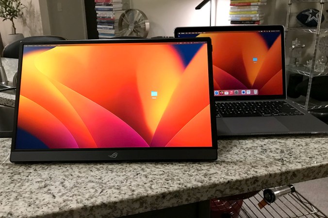  ASUS Rog Strix portable monitor showing an orange background while sitting on a kitchen counter