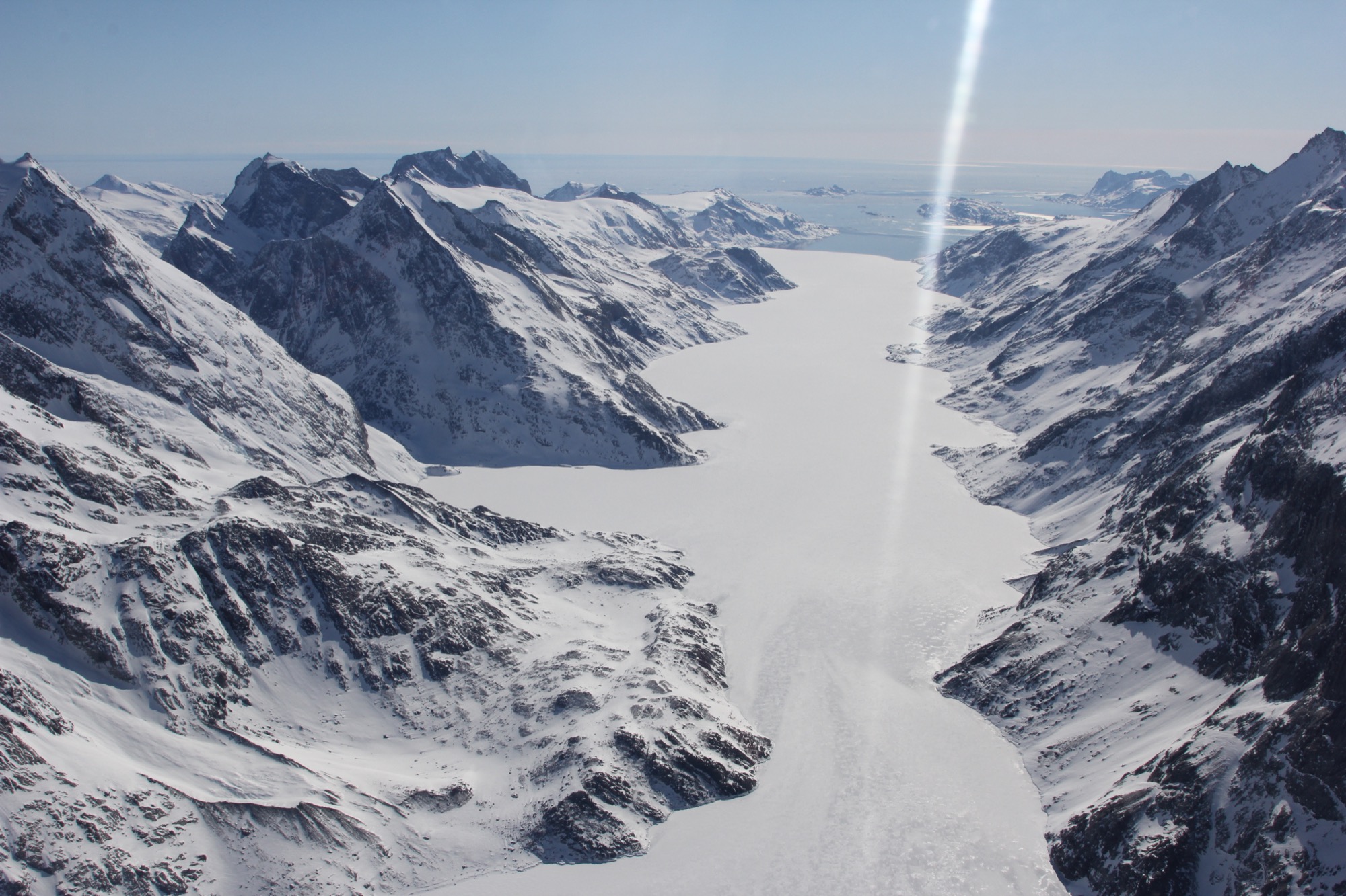 an ice covered landscape of mountains and a valley of fast ice cutting through