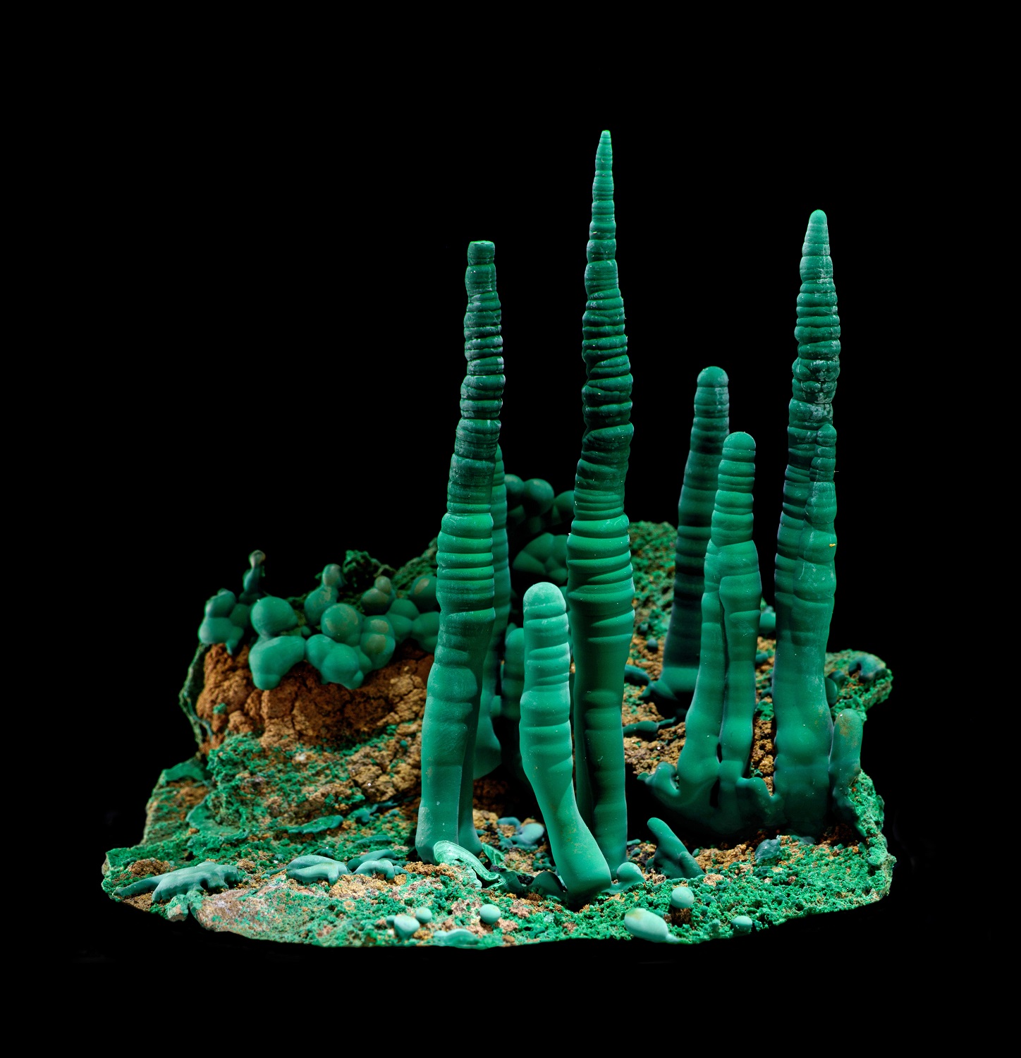 Green malachite pillars on a black background in a mineral catalog