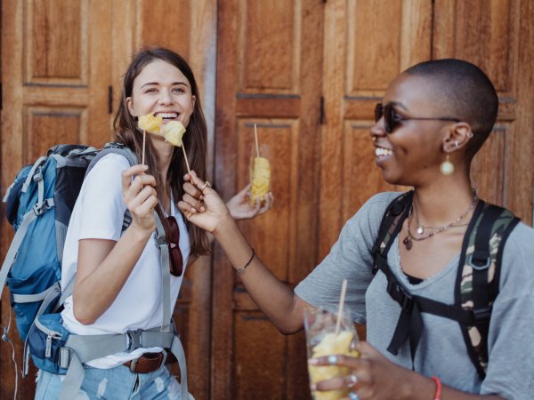 travelers eating street food laughing