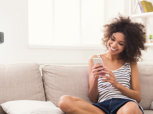 A woman sitting on a couch using her cellphone