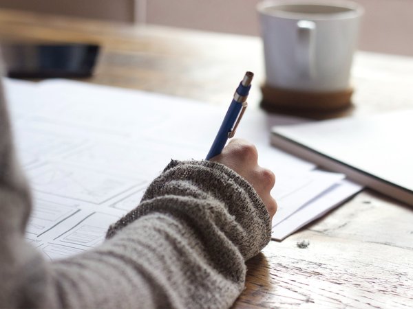 A person uses a pen to take notes