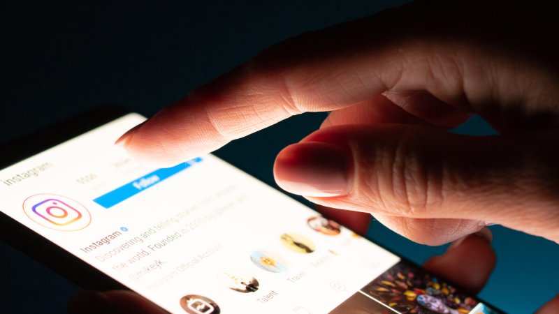 close up of girl's hand using smartphone with instagram app