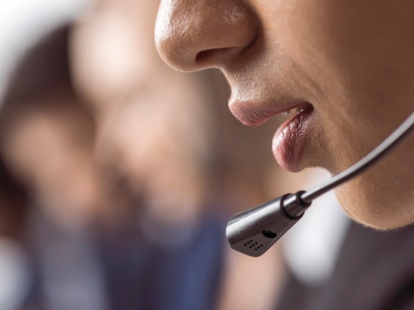 Close up of woman's mouth and headset microphone speaking at a call center