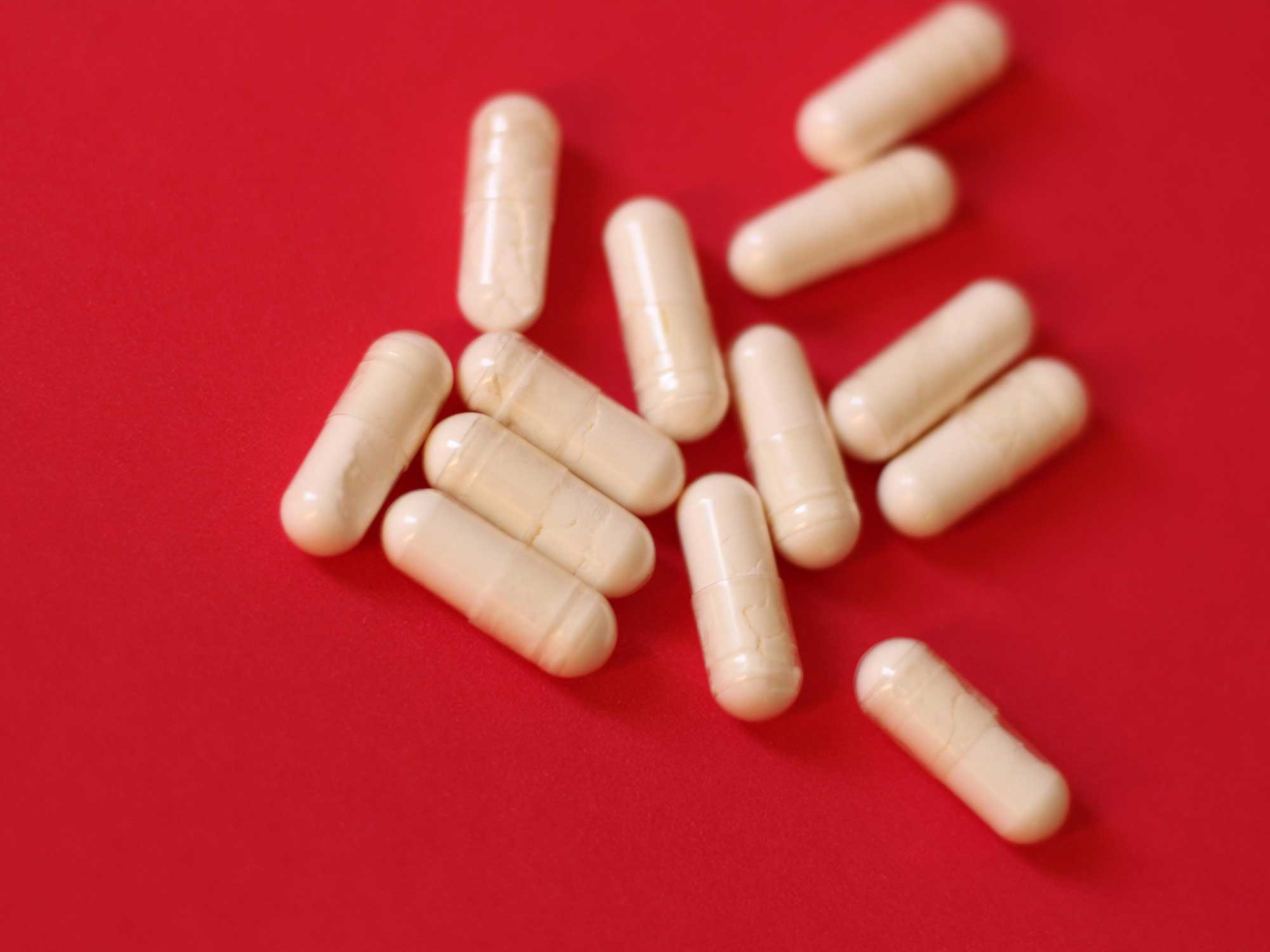 White diet pills on red background
