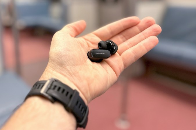 Bose QuietComfort Earbuds II in my hand on a Metro train