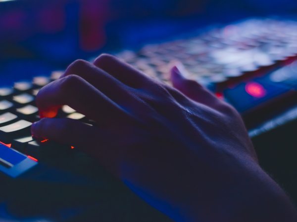 Hand typing on keyboard in dark room