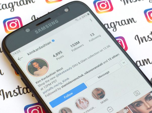 Kim Kardashian official instagram account on smartphone screen on paper instagram banner