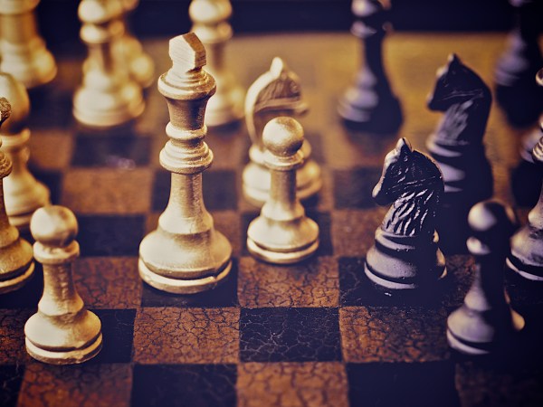 Close up on wooden chess board with chess pieces in play