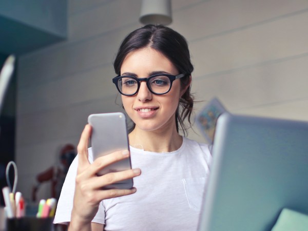 Person working with laptop in front looking at phone