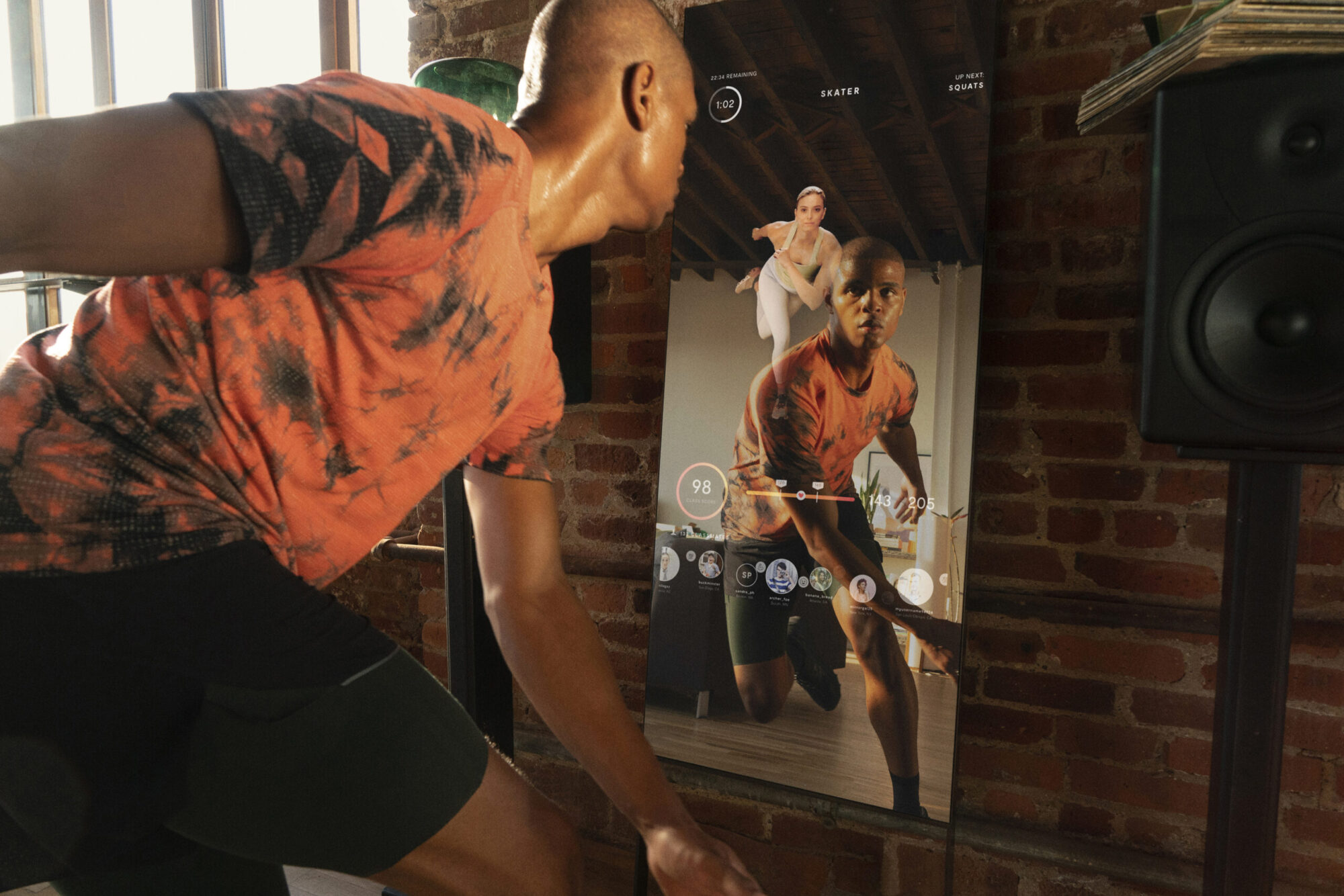 A person working out in front of a lululemon Studio Mirror in their home