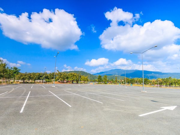 Empty parking lot underneath blue sky with clouds