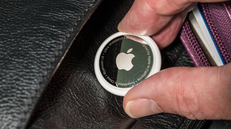  Apple AirTag being inserted into a leather purse