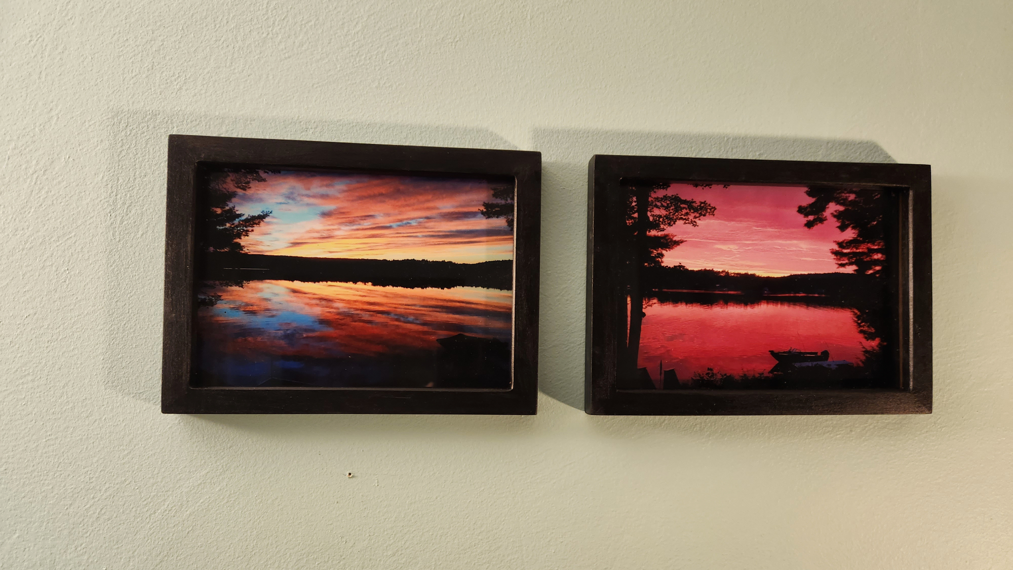 Two DIY picture frames next to each other on a beige wall, with sunset photos inside them.