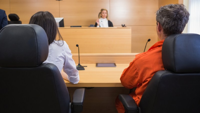 Lawyer and client listening to judge in the court room