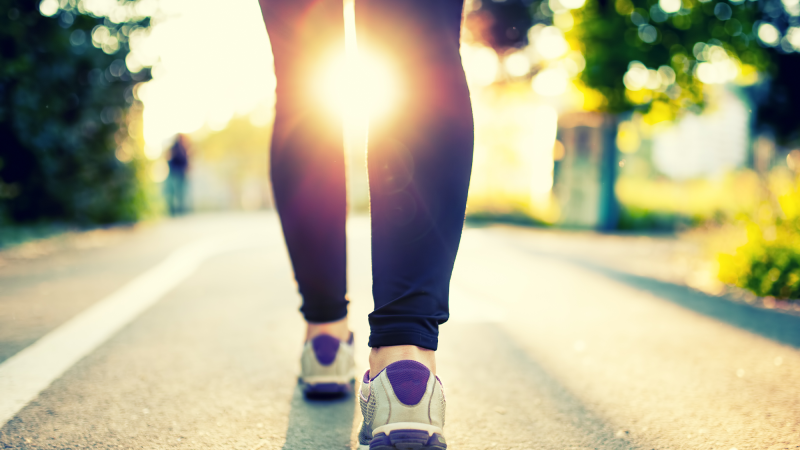 A woman walking into the sunset