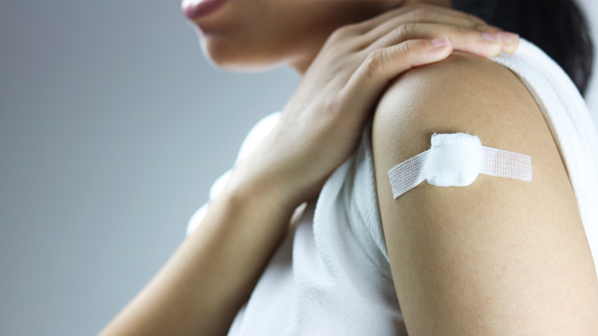 A woman with a bandage after receiving a vaccine.