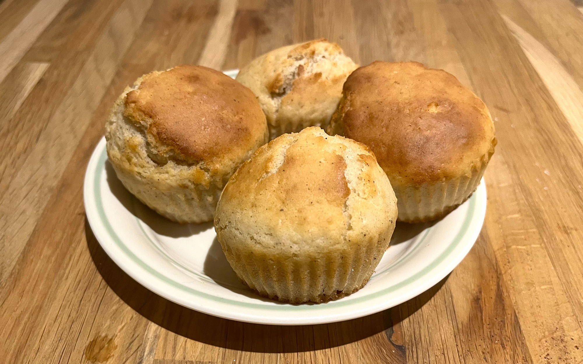 plate with four muffins over kitchen wooden counter