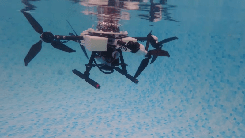 Quadcopter drone propelling itself underwater in swimming pool