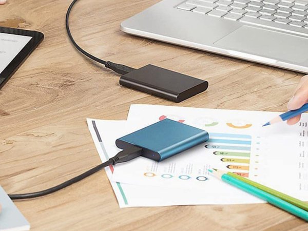 Two small solid state drives on a wooden desk