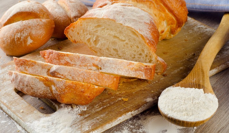 White bread loaf cut into slices with spoonful of soybean flour