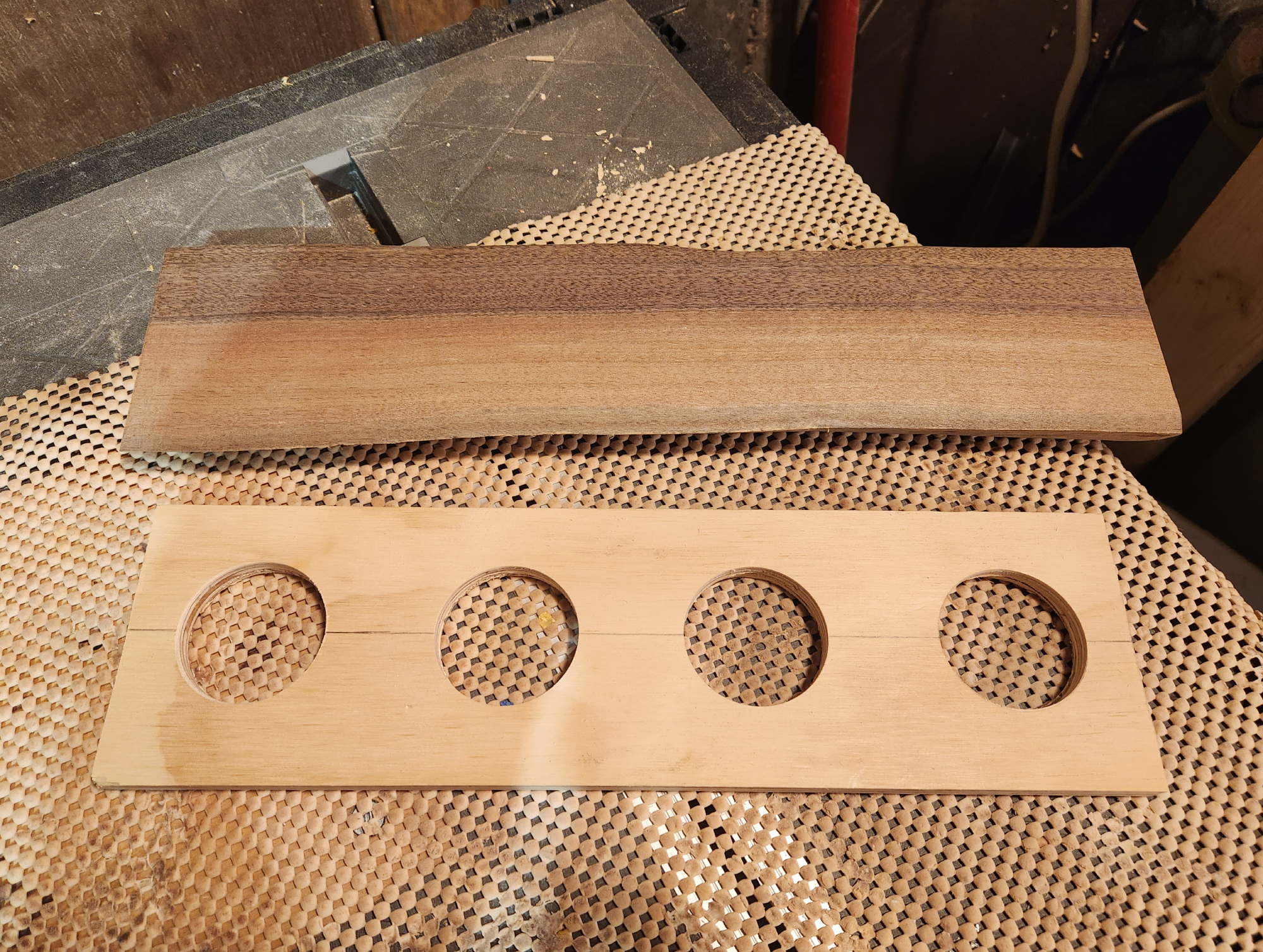 A plywood beer flight board hole template below a live edge beer flight board, before any cup holes have been cut.