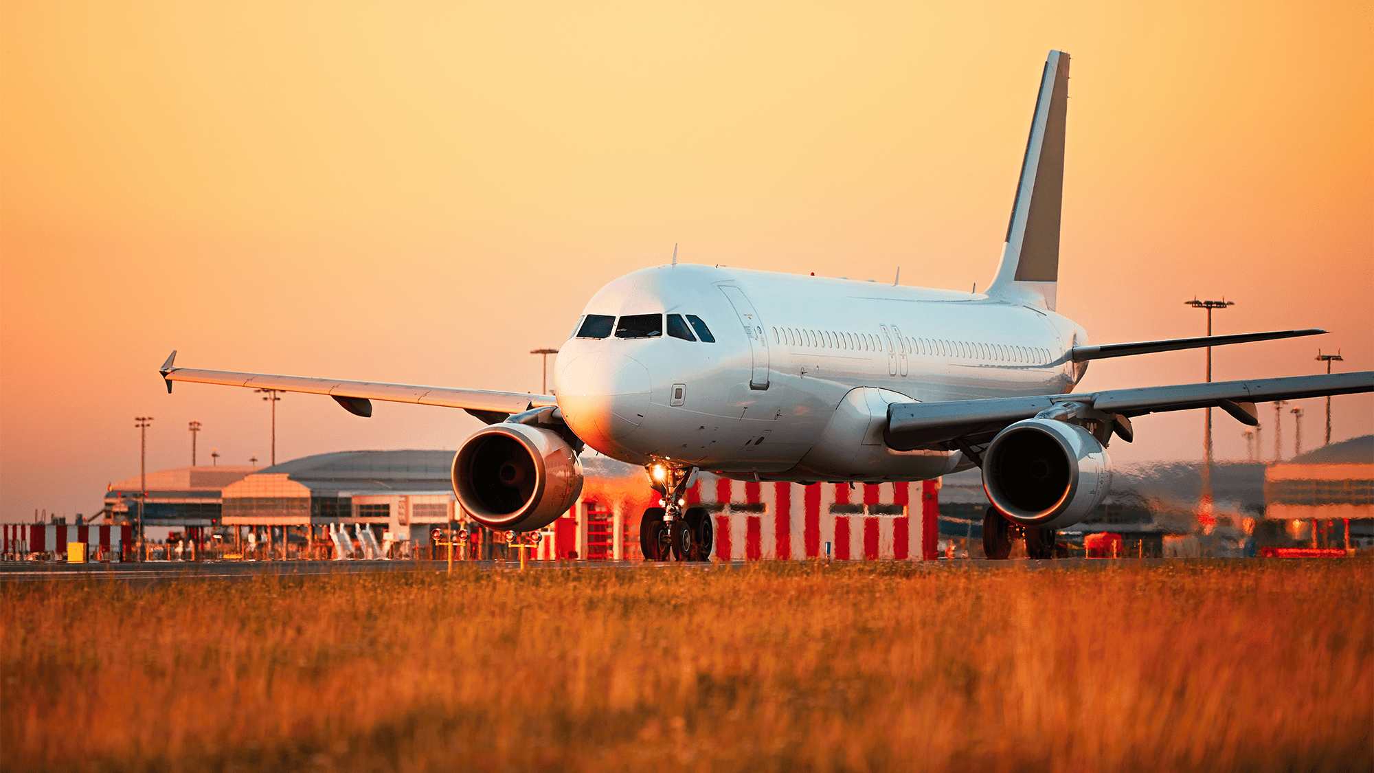 A commercial airplane at taxxing at an airport in soft sunlight.