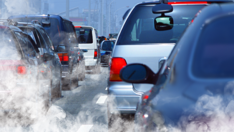 Cars in a traffic jam emitting exhaust.