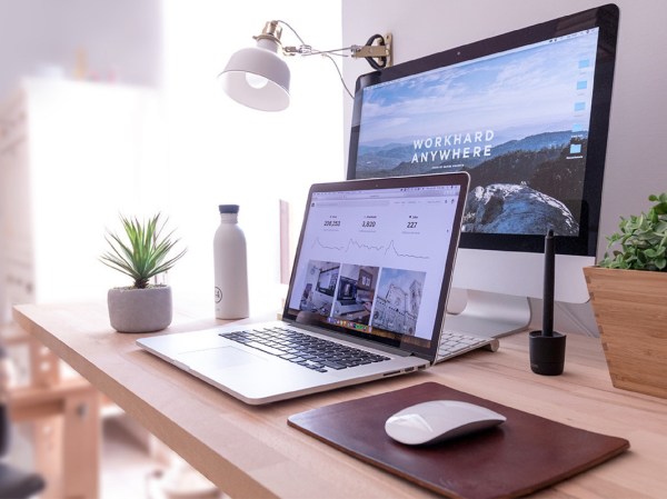 A laptop in front of a desktop computer